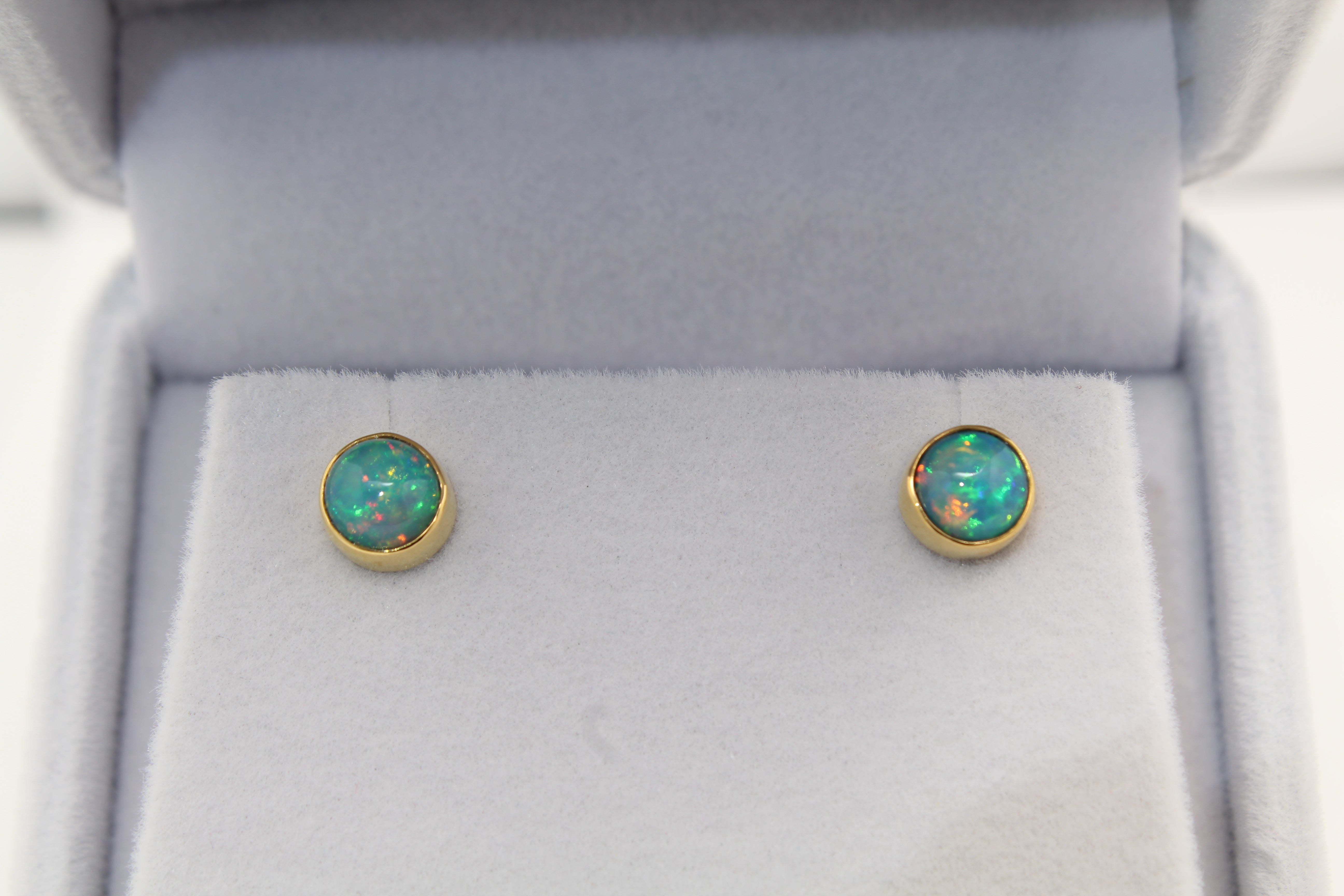 Round Ethiopian Opal stud earrings displaying vibrant orange fire, set in 22k and 14k gold