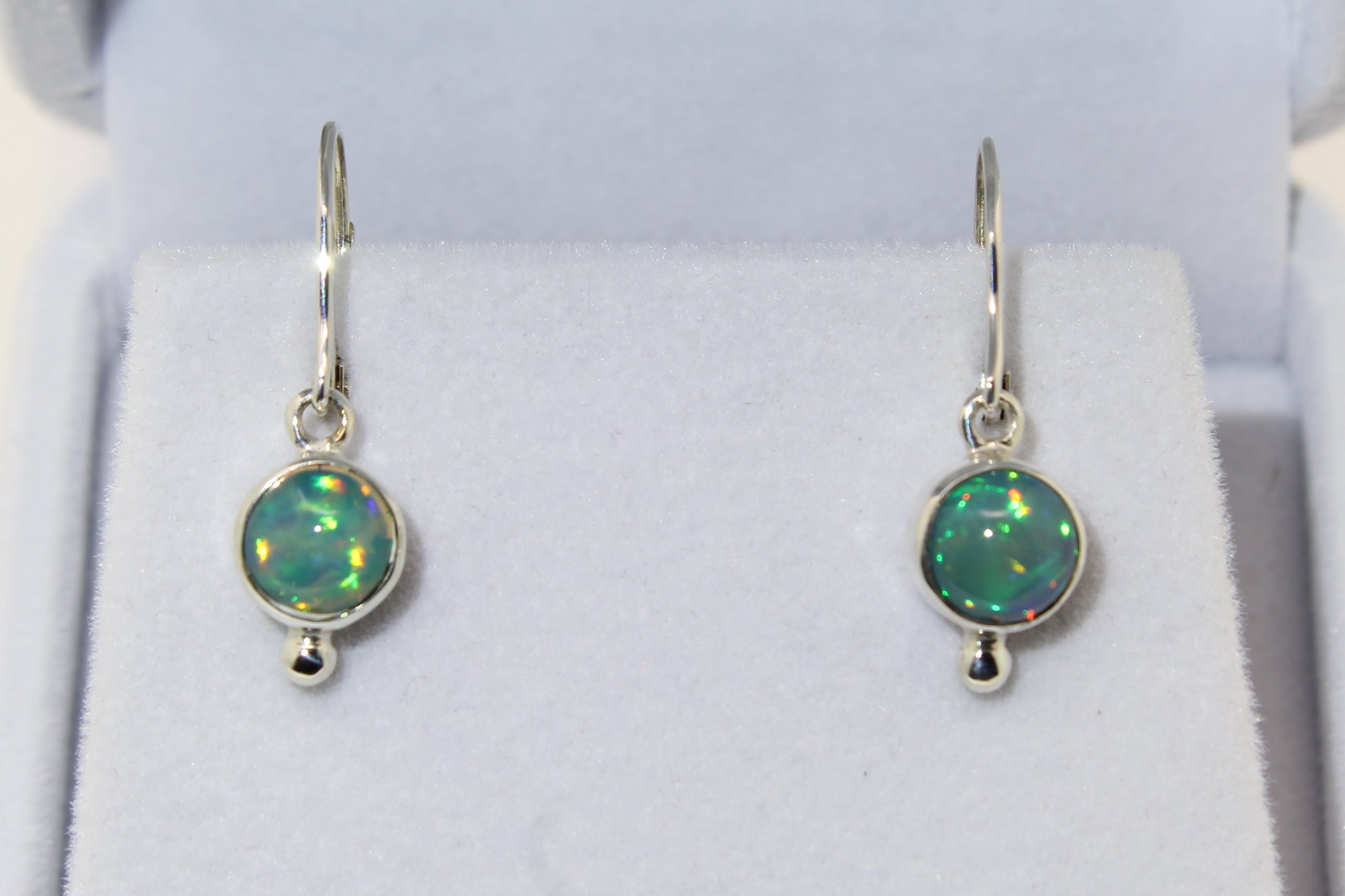 Opal earrings in a jewelry box on a white background
