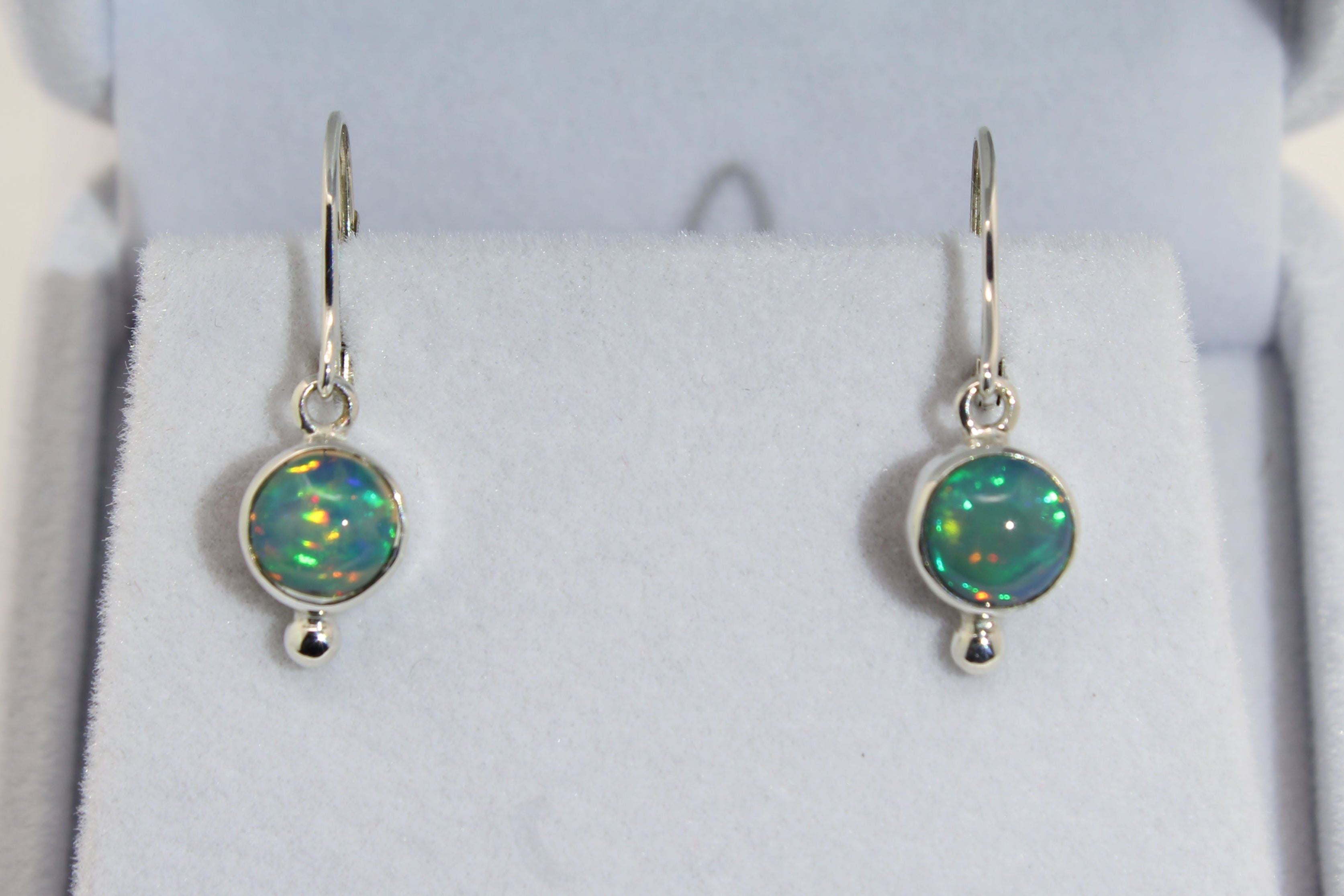 Silver opal earrings in a jewelry box